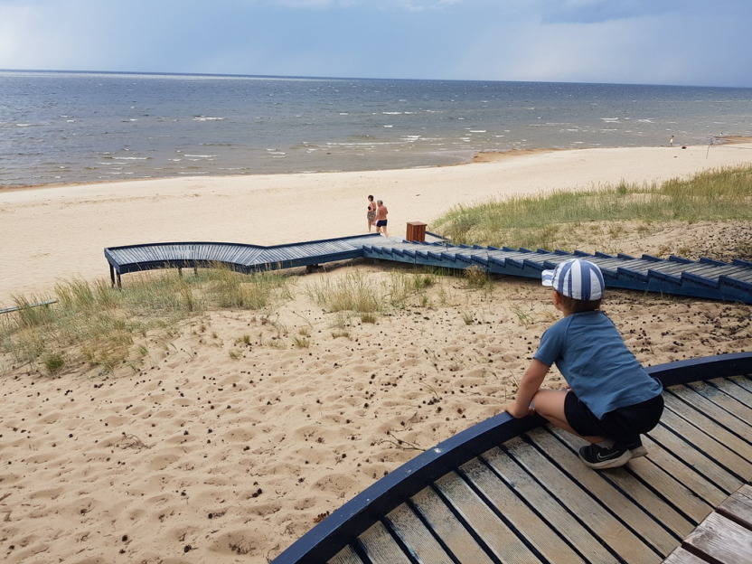 Lapsi istuu Peipsin hiekkarannalla katse kohti metra